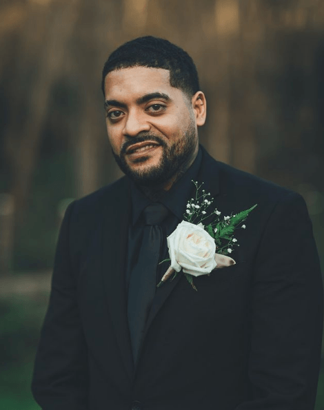 Trajes negros para novio flor blanca